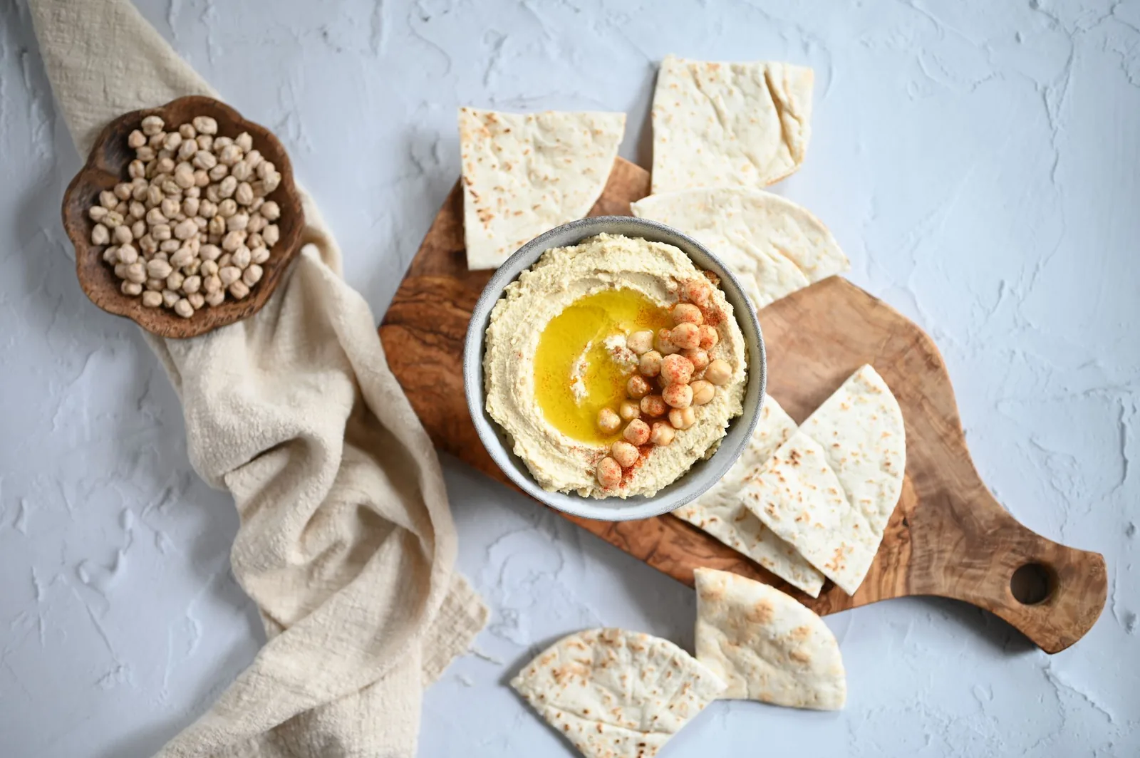 Zdravi domaći umaci i dodaci jelima: tahini, maslinovo ulje, jabukovo sirće, senf i limun na drvenom stolu